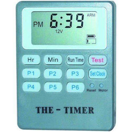 "Image of several Feeder Timers arranged on a workbench. The timers are compact and feature clear digital displays with simple, user-friendly buttons for easy programming. Each timer is encased in a durable plastic shell."